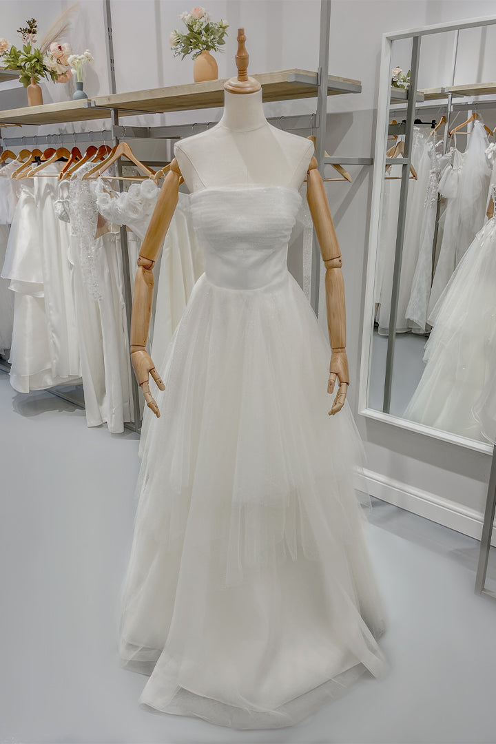 Тюлените етажи правят тази булчинска рокля идеален избор за официална рокля.