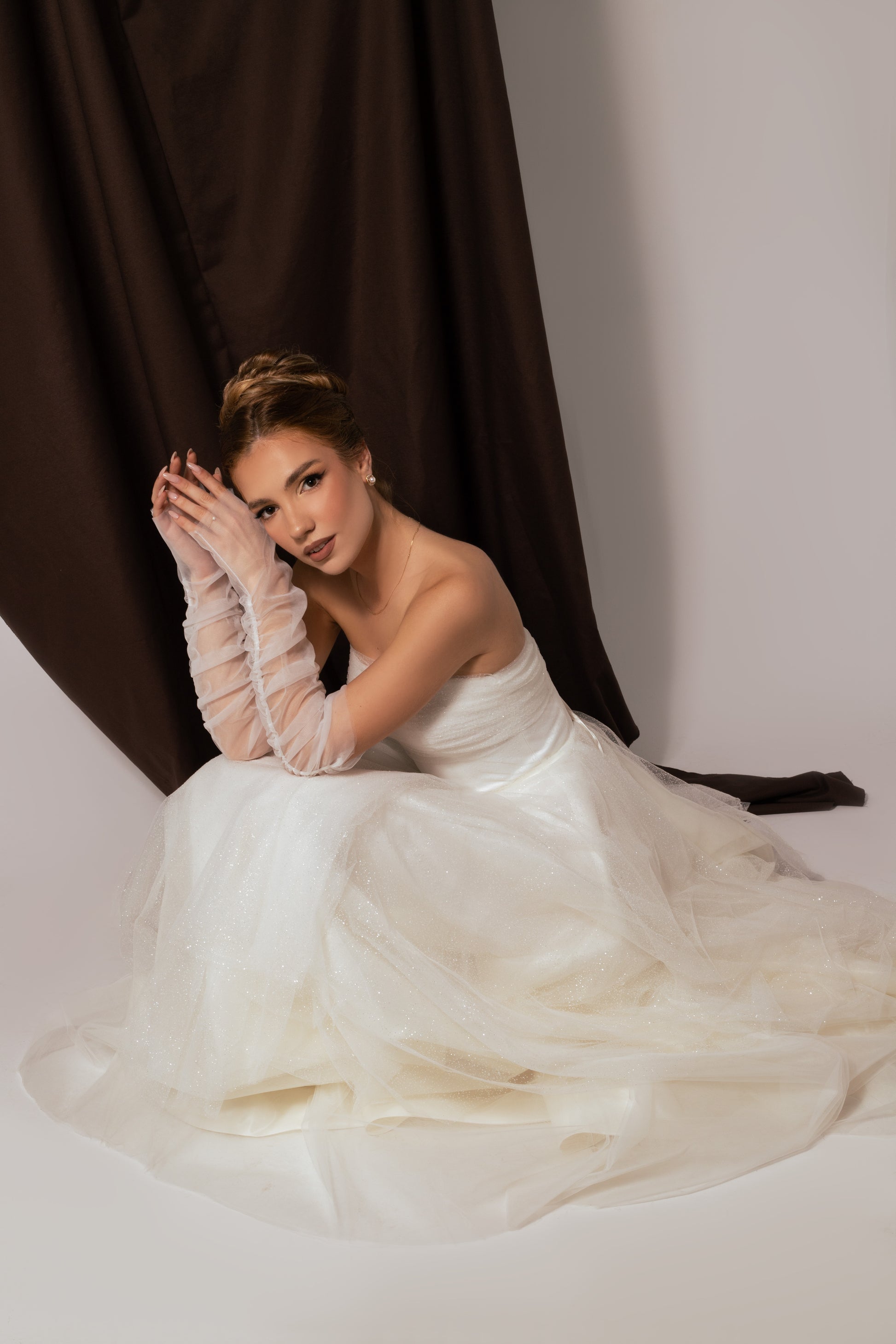 Тюлените ръкавици на тази булчинска рокля са прекрасно попълнение за официална рокля.