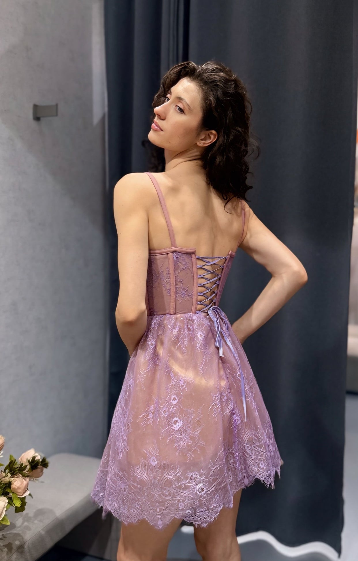 Задна част на официална рокля от лилава френска дантела, корсетирана с връзки. Подходяща за смел избор на абитуриентска рокля.