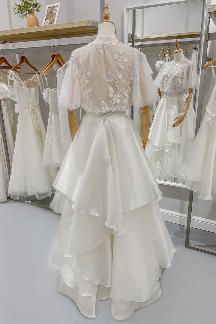 Дълга булчинска рокля Eleanor LIZA KAIN София от две части. Официална бяла рокля. Свободна горна част с ръкави от тюл. Детайли от флорална дантела на гърба. Обемна с колан и воали. 