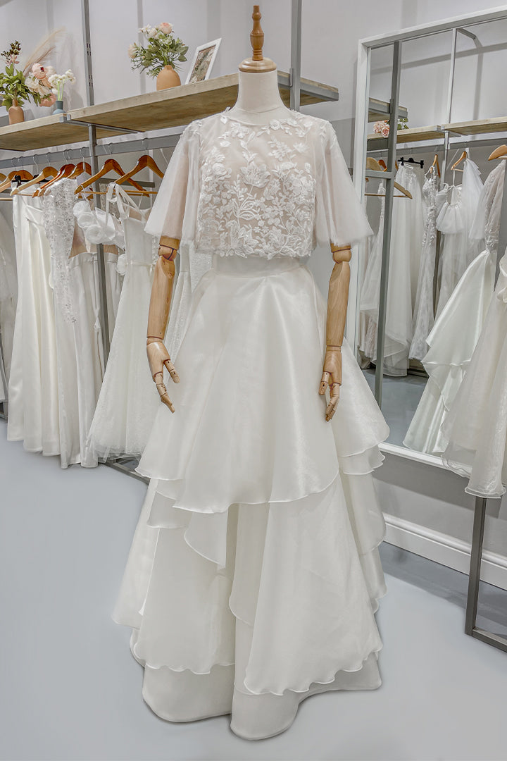 Дълга булчинска рокля Eleanor LIZA KAIN София от две части. Официална рокля от две части. Блуза с ръкави от тюл и флорална дантела. Обемна пола от органза с колан и воали. 