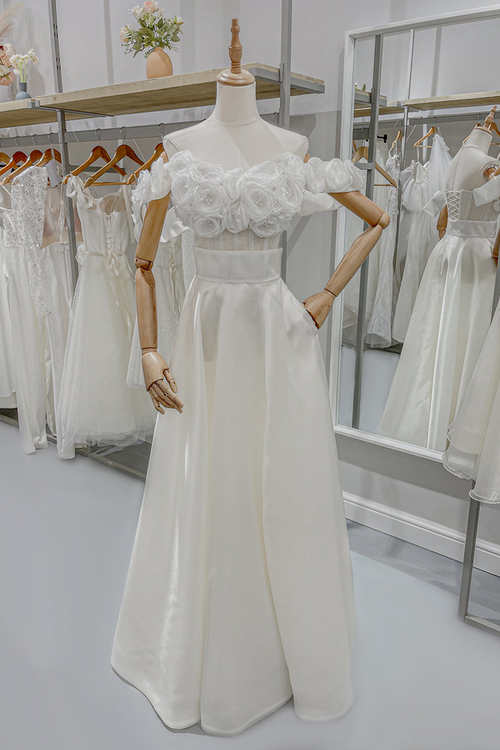 Дълга булчинска рокля Beatrice LIZA KAIN София. Бяла официална рокля от две части. Прозрачен корсет с апликации от цветя от органза и паднали презрамки. Разкроена пола от органза с широк колан и цепка. Джобове. 