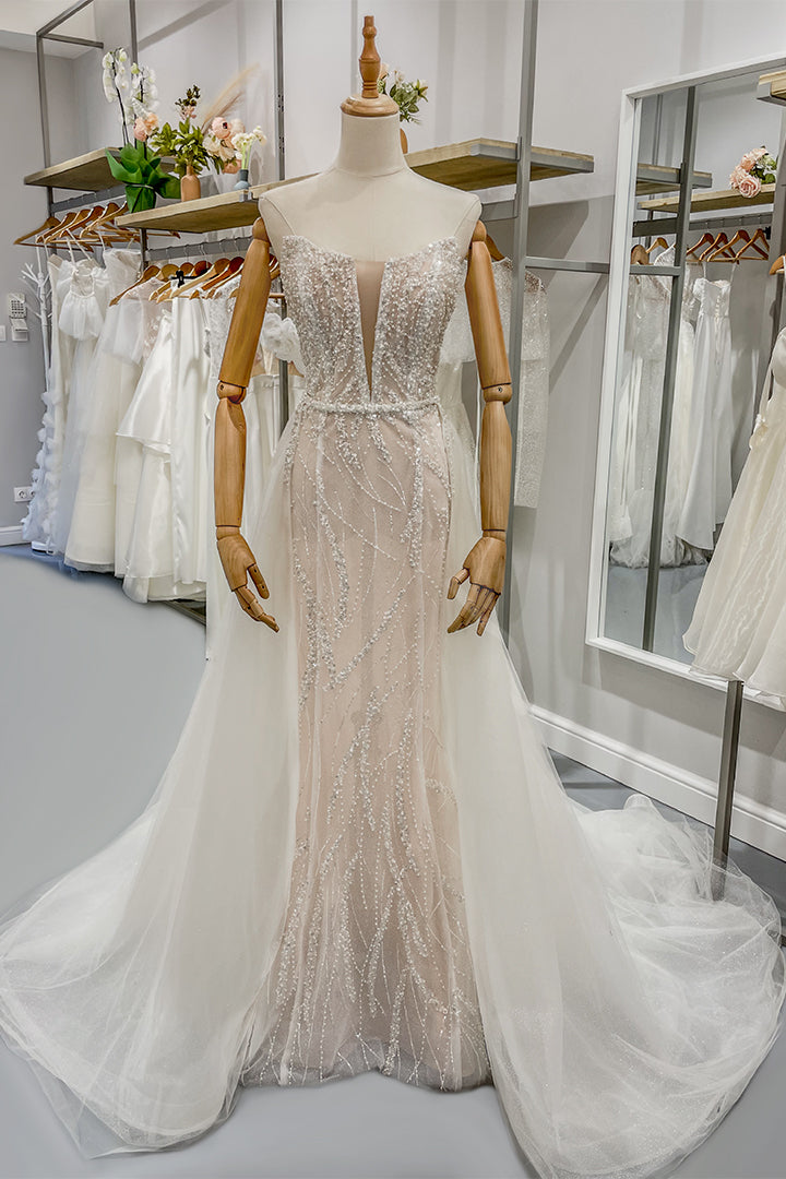 Дълга булчинска рокля русалка Rubelle Grande LIZA KAIN София. Бяла официална рокля с телесна основа, покрита с дантела от мъниста и перли. Изострен корсет с V-образно деколте с мрежа. Основна пола по тялото и бухнала тюлена пола с колан от перли.