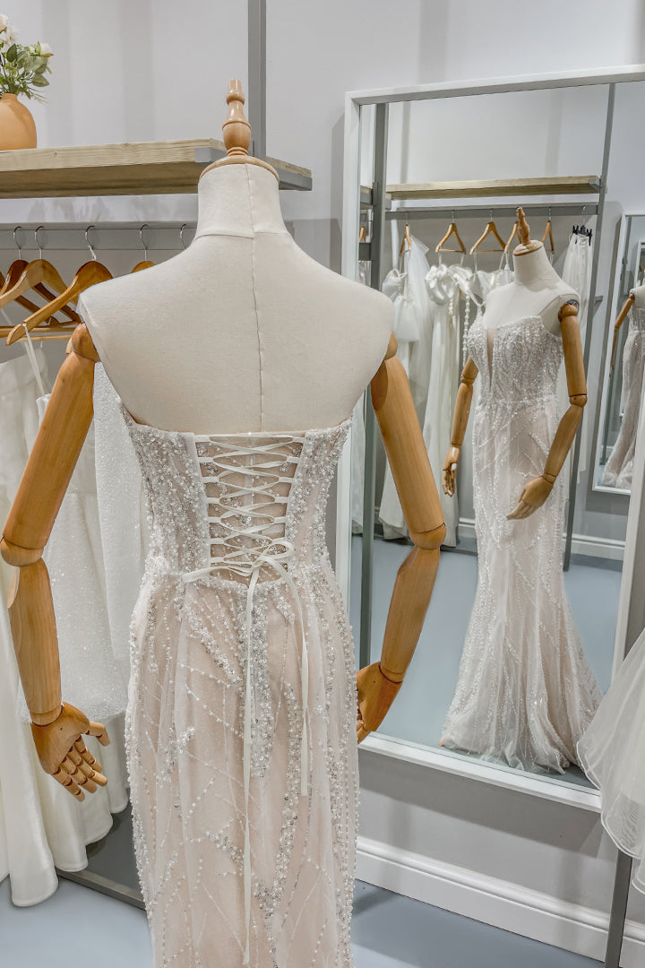 Дълга булчинска рокля русалка Rubelle LIZA KAIN София. Бяла официална рокля с телесна основа, покрита с дантела от камъчета и перли. Корсет с връзки и прозрачен панел на гърба. Оформящ силует.