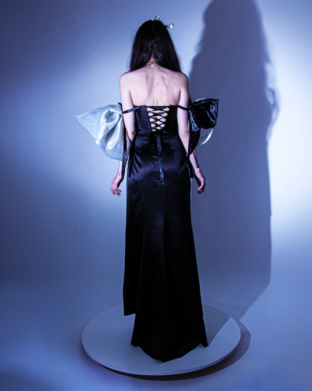 Официална дълга абитуриентска рокля с изчистено деколте, леки чупки в долната част, акцентни елементи по ръкавите и връзки за пристягане на гърба.