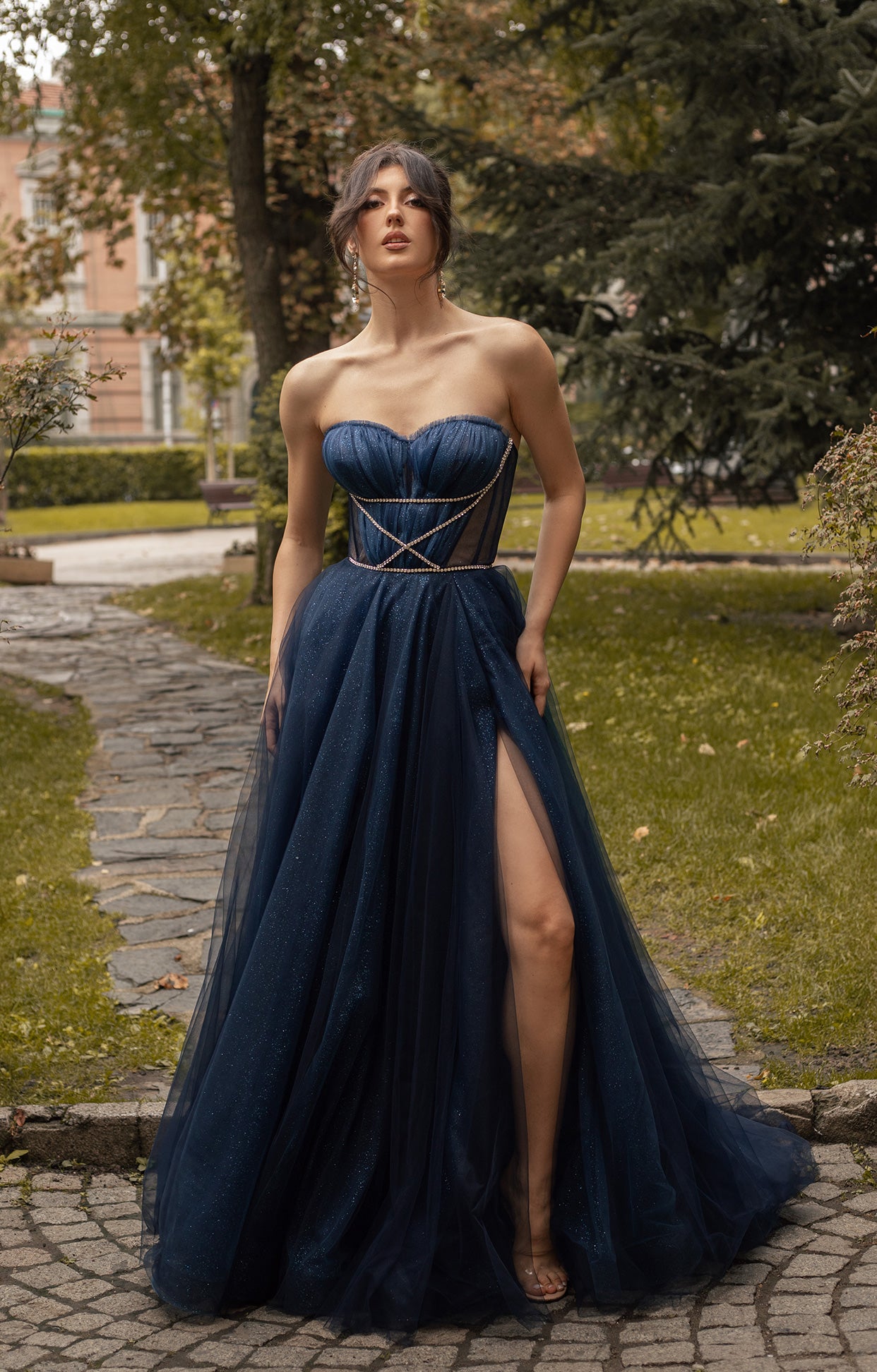 Официална дълга абитуриентска рокля Etara LIZA KAIN София. Обемна тъмносиня тюлена рокля. Сърцевидно деколте с набран тюл и апликации от сребристи камъчета. Многослойна обемна тюлена пола с висока цепка.