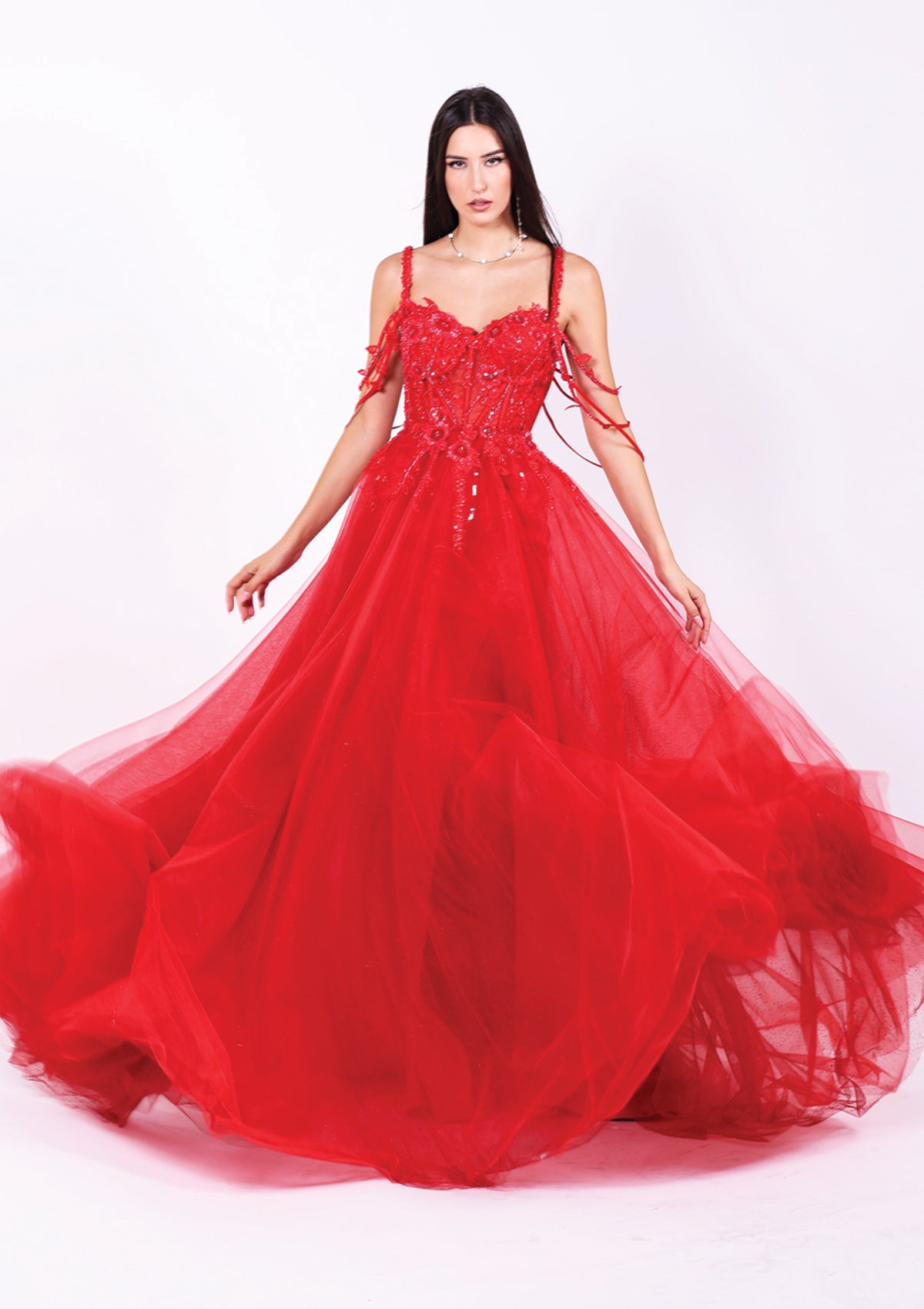 Дълга абитуриентска рокля Hessonite LIZA KAIN София. Официална рокля от яркочервен тюл. Корсет със сърцевидно деколте и множество тънки паднали презрамки, покрит с флорална червена дантела. Апликации по талията. Бухнала тюлена пола.