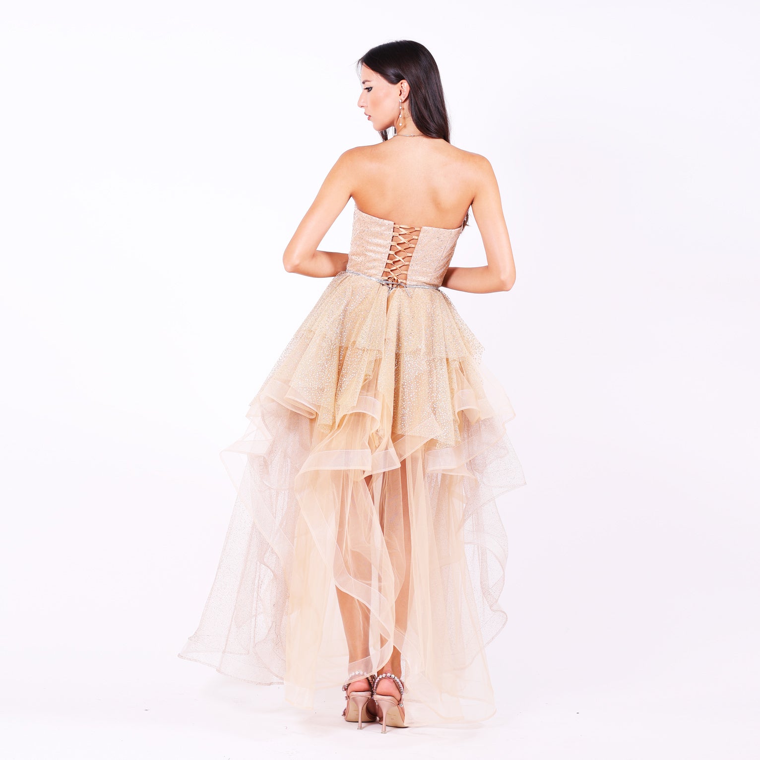 Къса абитуриентска рокля Nerium LIZA KAIN София. Официална рокля от бежов сатен и тюл. Корсет без презрамки с връзки на гърба. Разкроена пола с множество къси и дълги къдрици от различни тюлове.