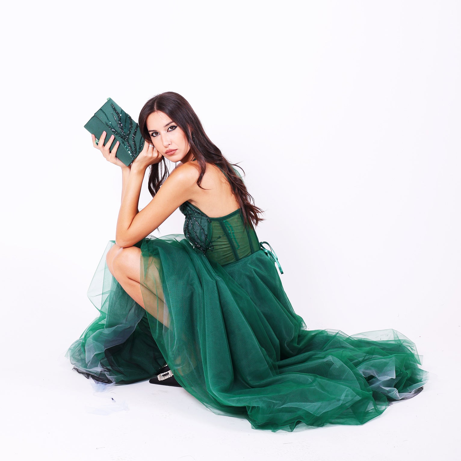 Дълга абитуриентска рокля Grevillea LIZA KAIN София. Официална рокля от тъмнозелен тюл. Корсет с полупрозрачна основа и апликации. Обемна тюлена пола от различни слоеве. Клъч.