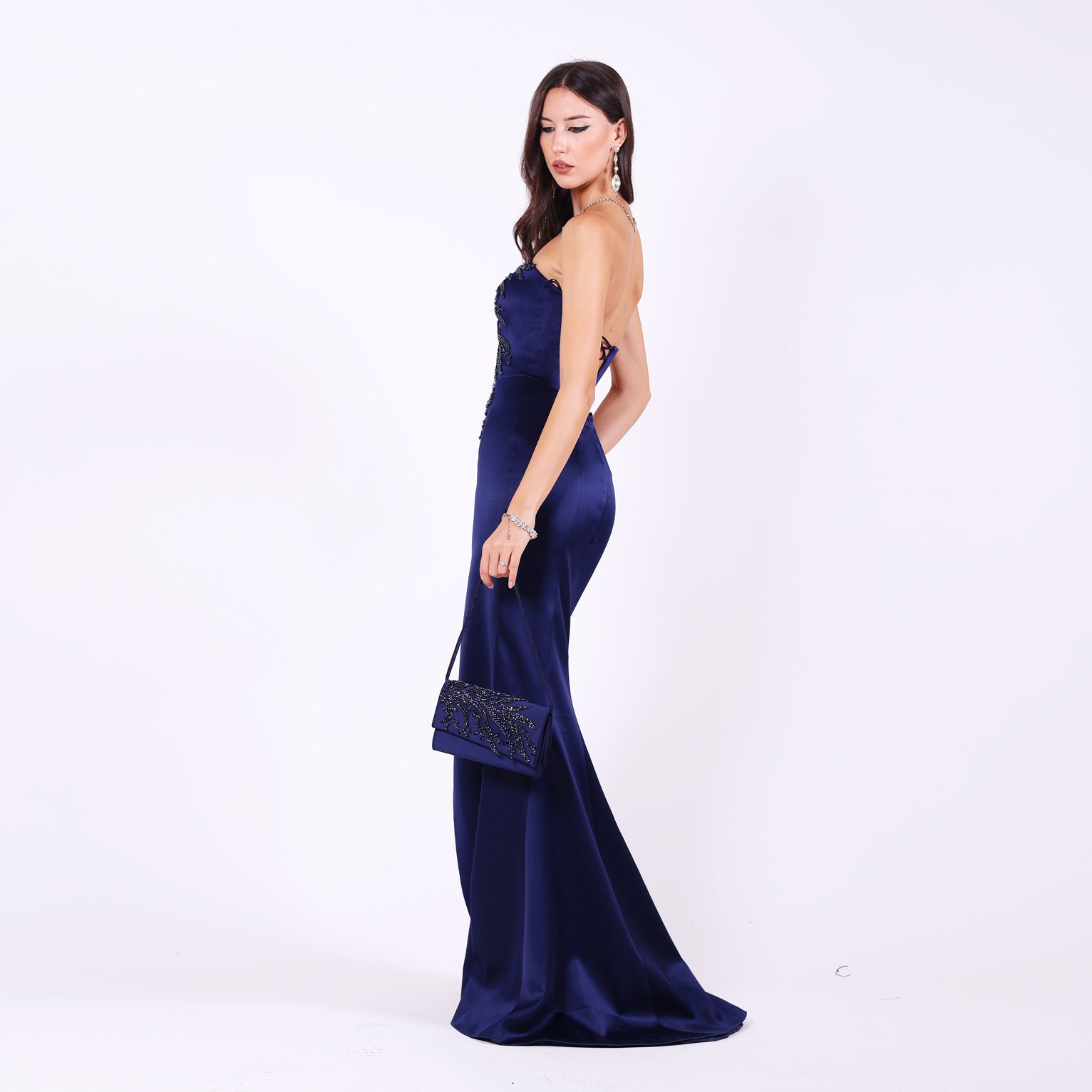 Дълга абитуриентска рокля Mathiola LIZA KAIN София. Официална рокля от тъмносин сатен. Корсет с равно деколте и мрежа, покрит с графитена дантела от камъчета и мъниста. Пола тип русалка с цепка.