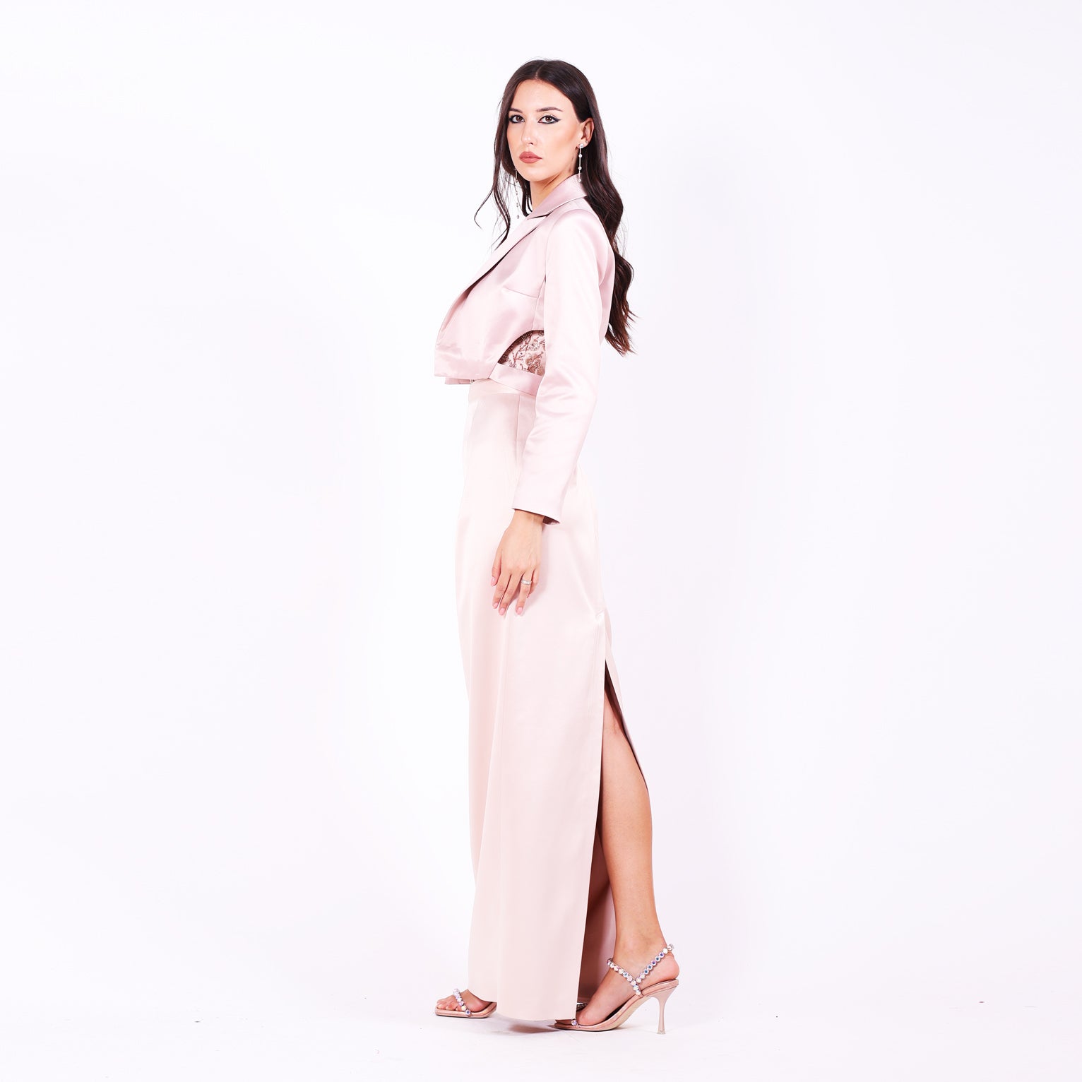 Дълга абитуриентска рокля Leea LIZA KAIN София. Официална рокля от светлорозов сатен. Корсет с равно деколте с апликации от розова флорална дантела от мъниста. Сатенен колан. Права сатенена пола по тялото. Сатенено късо сако с класическа яка и дупки на талията.