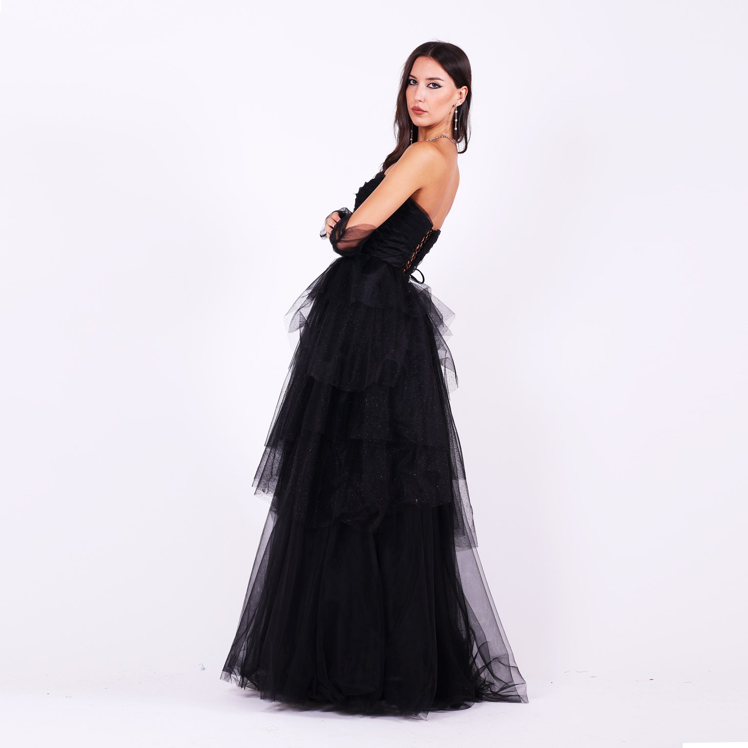 Дълга абитуриентска рокля Gloxinia LIZA KAIN София. Официална рокля от черен тюл. Корсет с връзки на гърба. Обемна тюлена пола на етажи с цепка. Тюлени ръкавици без пръсти.