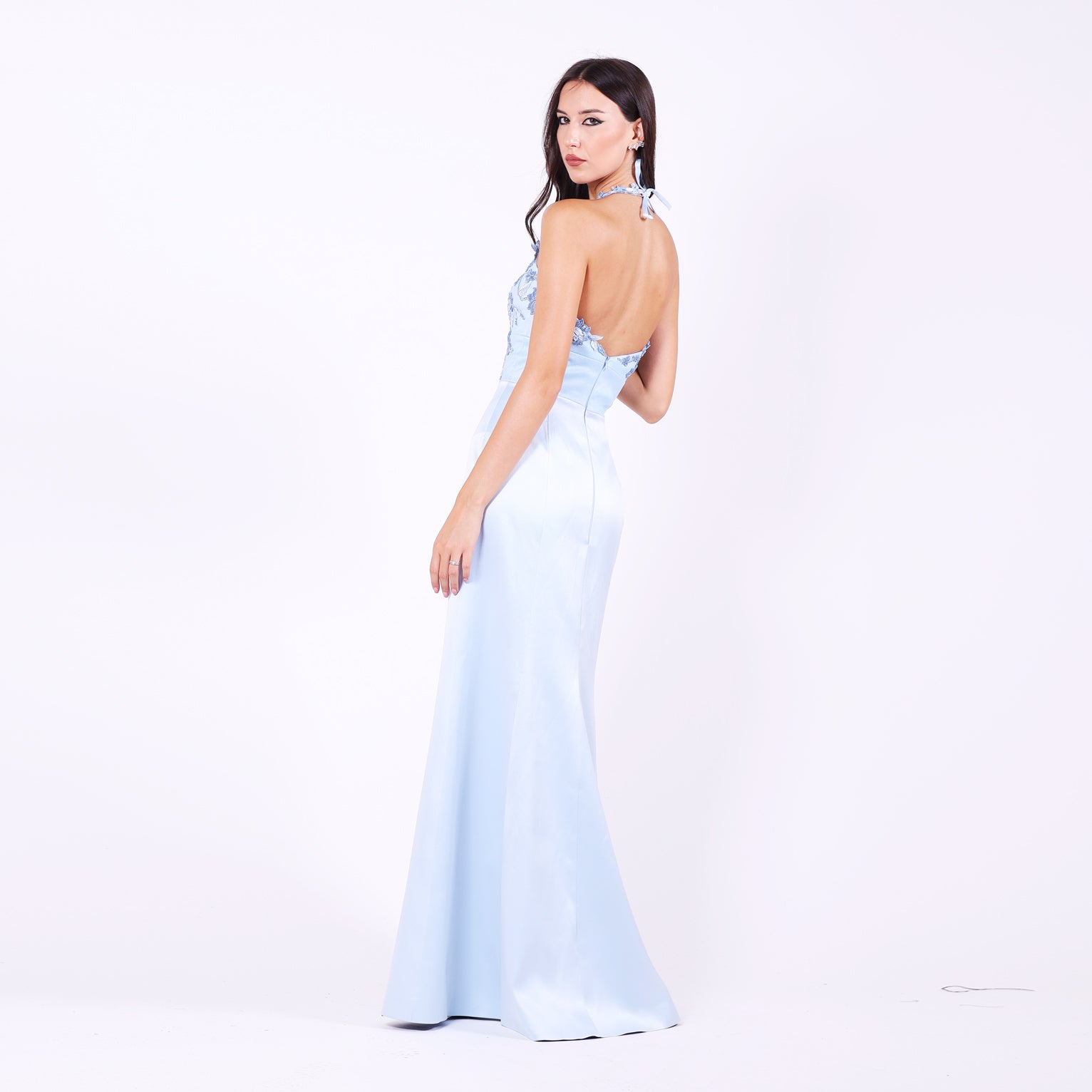 Дълга абитуриентска рокля Albizia LIZA KAIN София. Официална сатенена рокля в светлосиньо. V-образно деколте с презрамки с връзване на врата. Отворен гръб. Пола по тялото с шлейф.