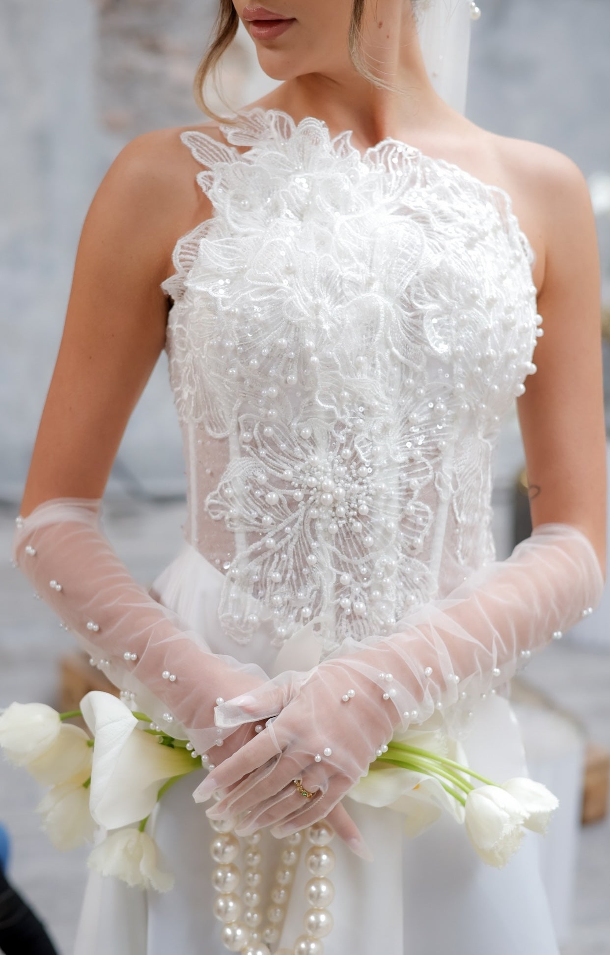 Елегантна булчинска рокля Emeralda Boheme LIZA KAIN Bridal с корсетирана асиметрична горна част, полупрозрачен корсет с декорация от перли и дантела, А-линия сатенена пола и фин шлейф.