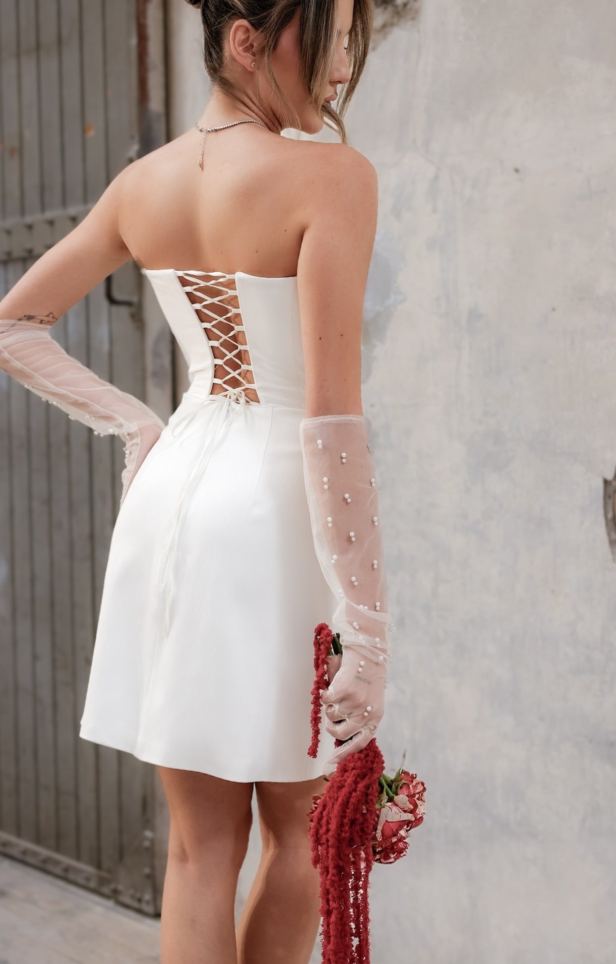 Официална къса булчинска рокля Lily Rose LIZA KAIN Bridal с корсетирана горна част, V-образно деколте, ръчно изработени флорални апликации с перли и камъчета и права пола.