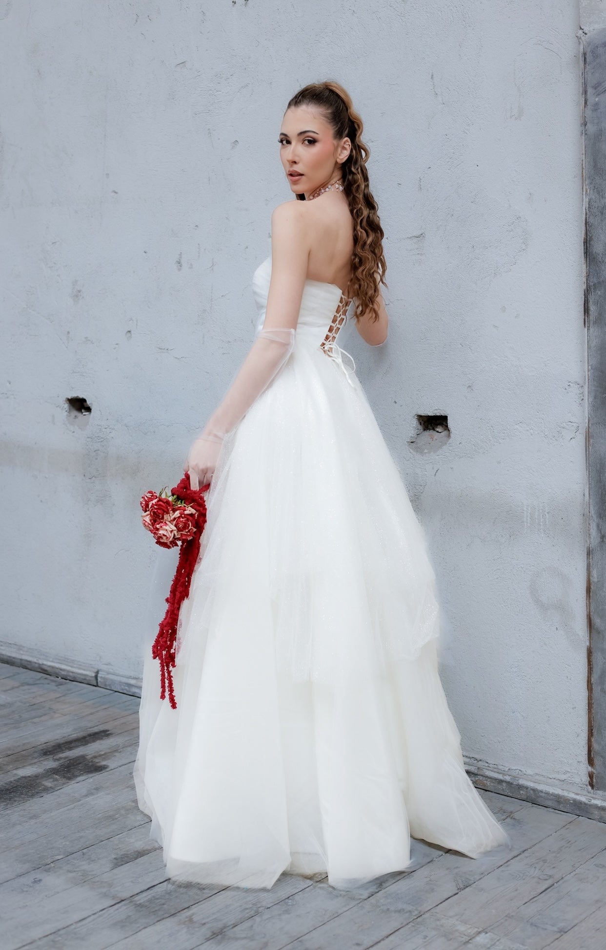 Дълга булчинска рокля Nerissa LIZA KAIN София с корсет, равно деколте с тюлена драперия и обемна многослойна пола от тюл с фин брокат. Закопчаване с връзки на гърба.