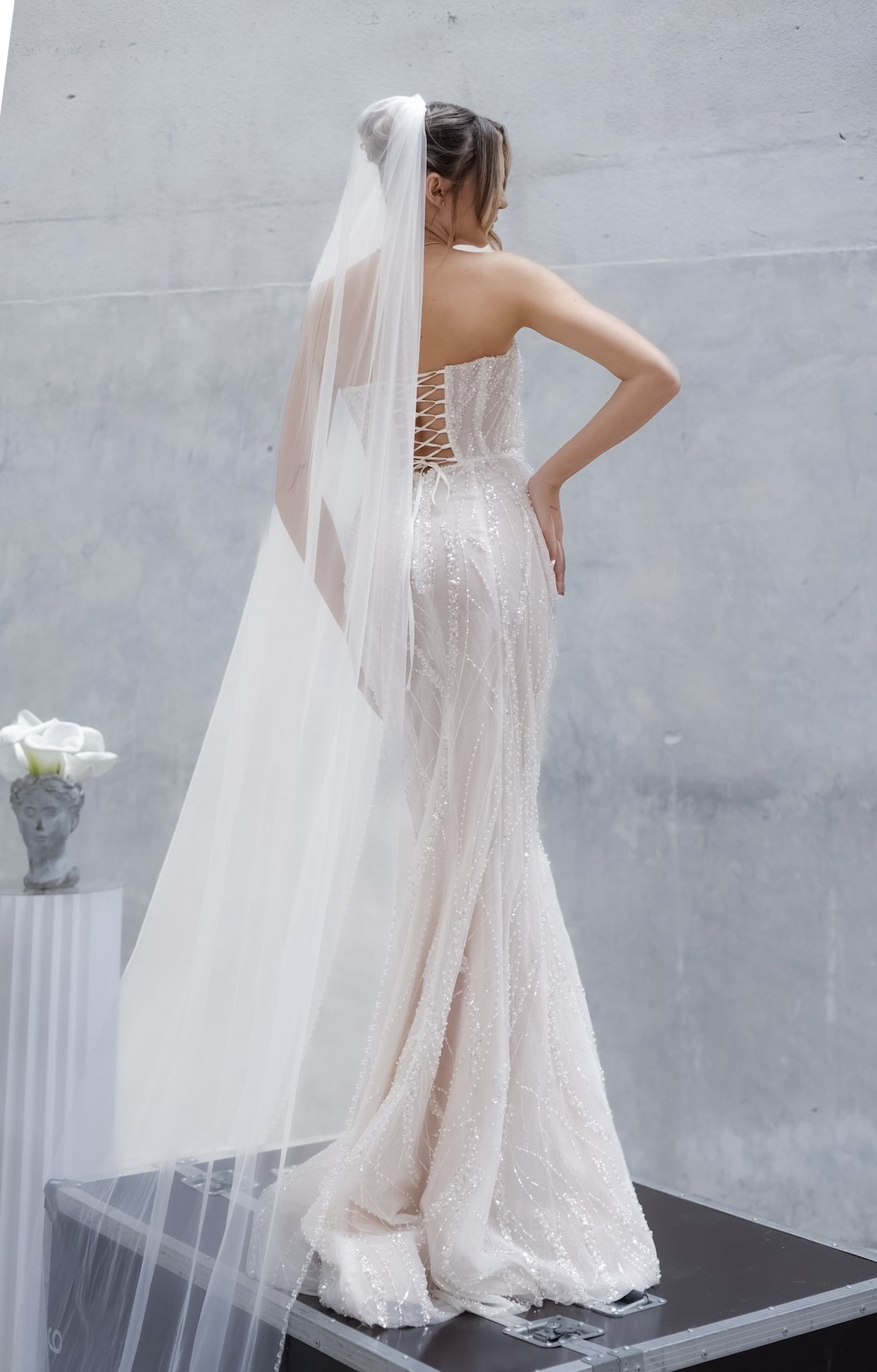 Дълга булчинска рокля русалка Rubelle LIZA KAIN София. Бяла официална рокля с телесна основа, покрита с дантела от мъниста и перли. Изострен корсет с V-образно деколте с мрежа. Пола по тялото тип русалка.