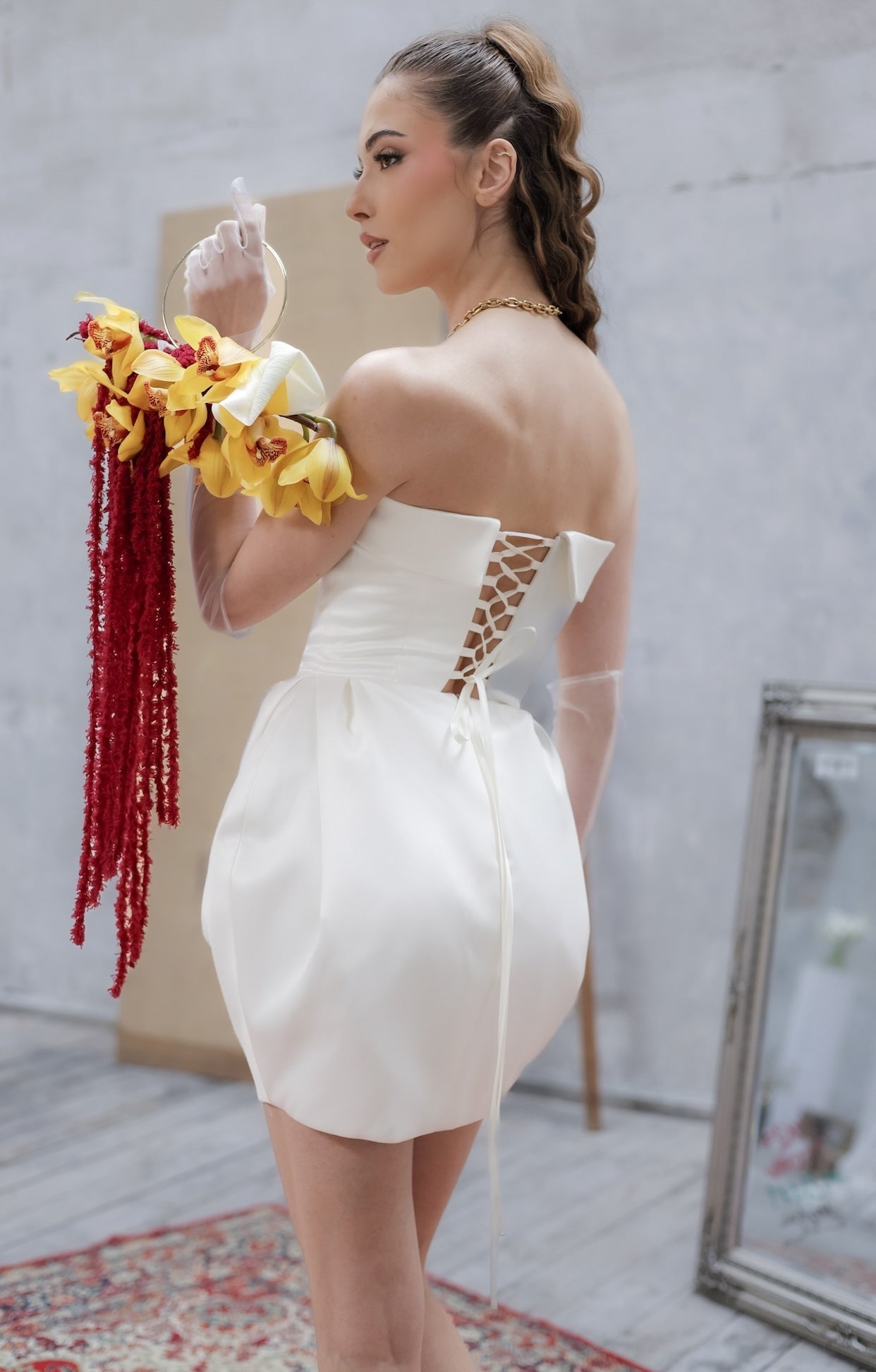 Елегантна къса булчиснка рокля Desdemona Whisper LIZA KAIN Bridal с корсет с оформена яка, триъгълна конструкция акцентираща върху талията и склуптурирана мини пола от бял сатен.Закопчаване с връзки на гърба.