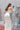 Задна част на корсета Margarita Lumière от LIZA KAIN bridal с метални капси, връзки и романтична панделка. Детайлът осигурява прецизно прилягане към тялото и красив финален акцент.