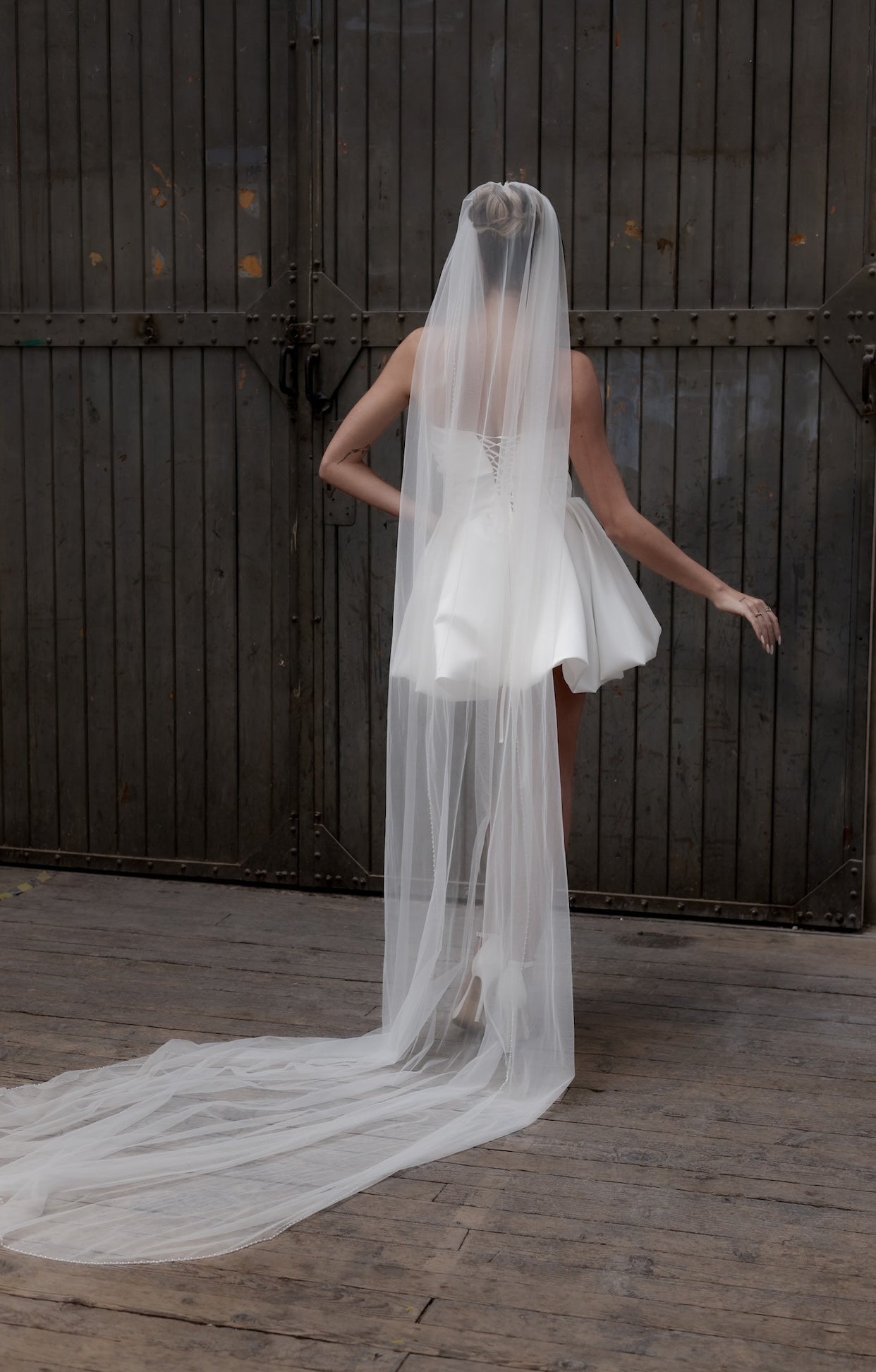 Официална булчинска рокля Isolde Blanche LIZA KAIN от бял сатен с изразен силует, корсет, отворено деколте с блестящи акценти и къса балон пола. Закопчаване с връзки на гърба.