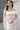 Горната част на роклята Hermione Lumière от LIZA KAIN bridal, акцентиращ върху деликатните паднали рамене. Този детайл разкрива изящно шията и раменете, като същевременно балансира изразително оформената талия. Композицията излъчва романтика и вечна класика.