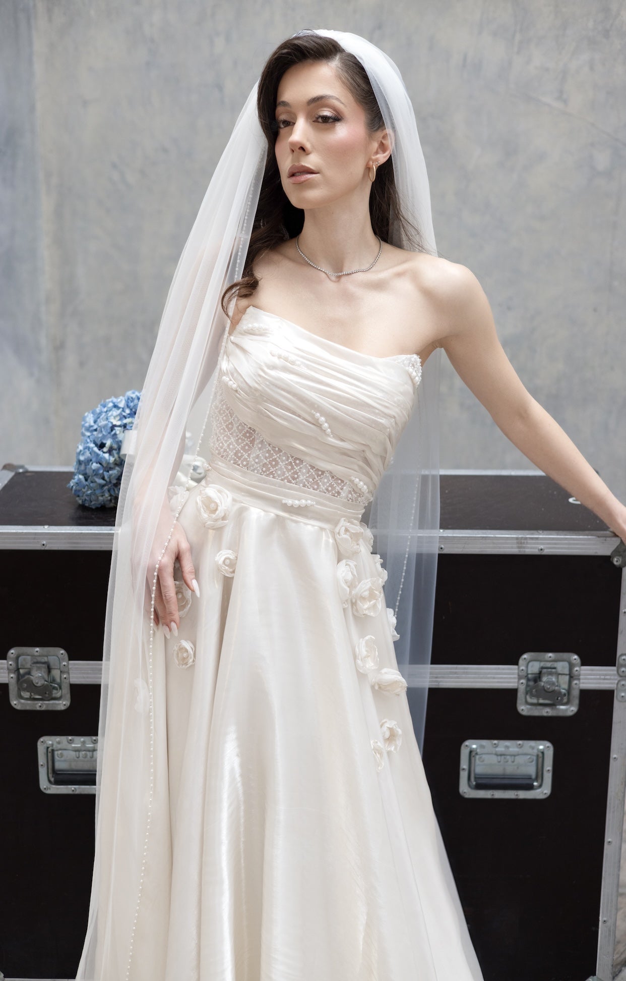 Елегантна булчинска рокля Moonblush LIZA KAIN Bridal от бяла органза с драпиран корсет, ръчно нашита дантела с перли и декорация от флорални елементи. Права пола с ръчно изработени апликации.