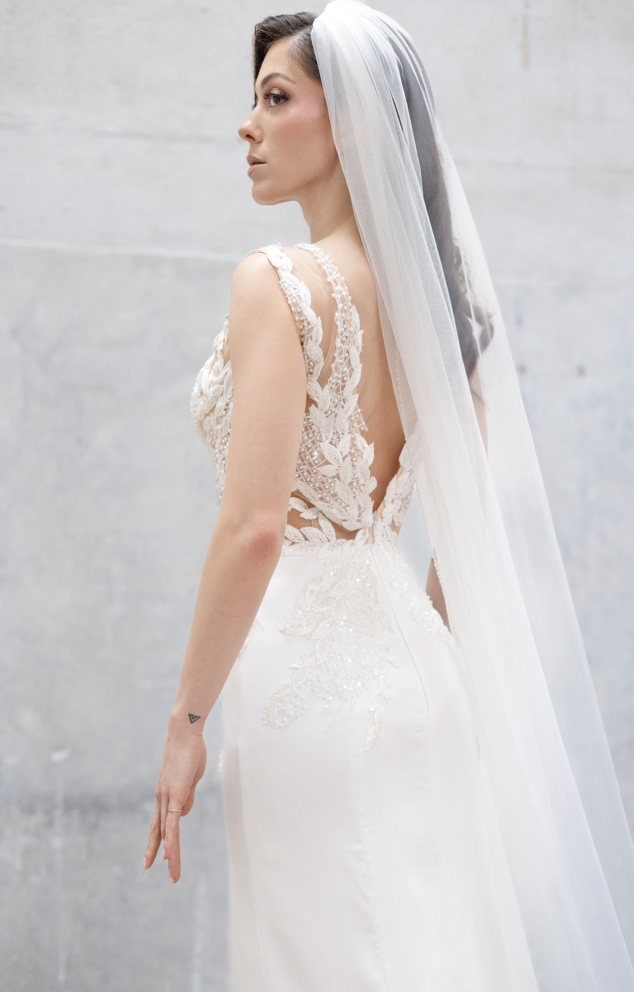Елегантна булчинска рокля Ivy Embrace LIZA KAIN Bridal с ръчна бродерия от листа и перли върху корсета, отворен гръб и очертаваща силуета гладка падаща пола.