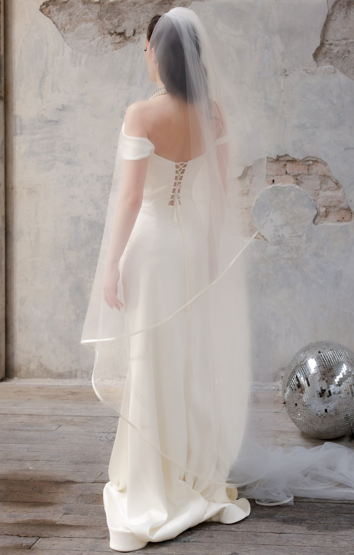 Официална булчинска рокля Hermione Lumiere LIZA KAIN Bridal с корсетирана горна част, детайл от паднали ръкави, издължен силует тип русалка и фин шлейф.