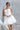 Къса официална булчинска рокля Elegant Mini LIZA KAIN Bridal с корсетирана горна част, V-образно деколте, детайл от тънък блестящ колан и тюлена пола. Пристягане с връзки на гърба.