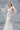 Официална булчинска рокля Caelina LIZA KAIN Bridal със скулпториращ силует, V-образно деколте и отворен гръб. Ръчно нашита дантела и пола тип русалка.