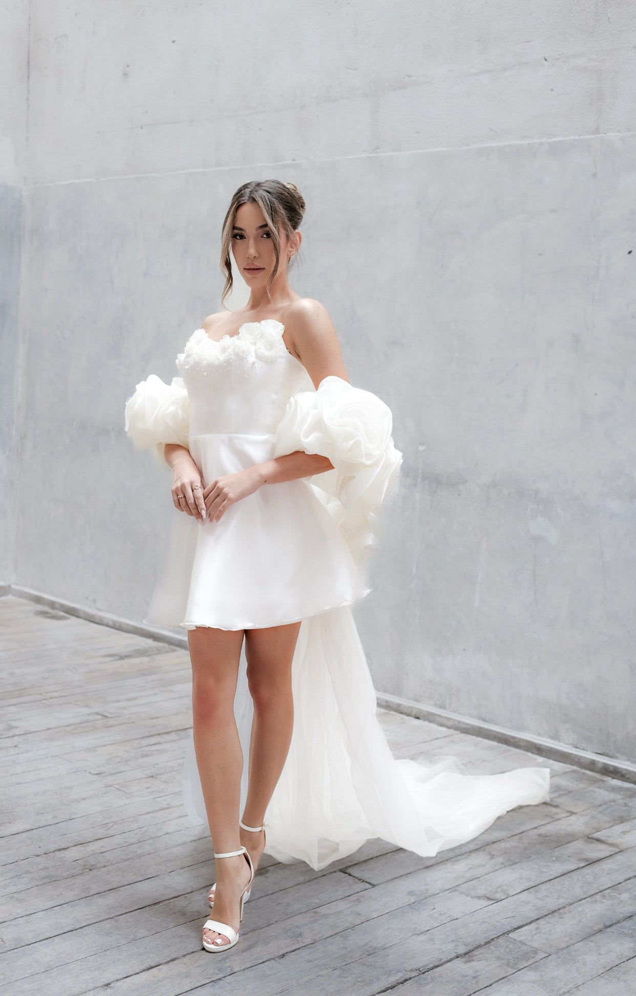 Официална къса булчинска рокля Helen LIZA KAIN Bridal от фина бяла органза, с корсетирана горна част и детайл от триизмерни флорални елементи с камъчета и перлички, и къса обемна пола.