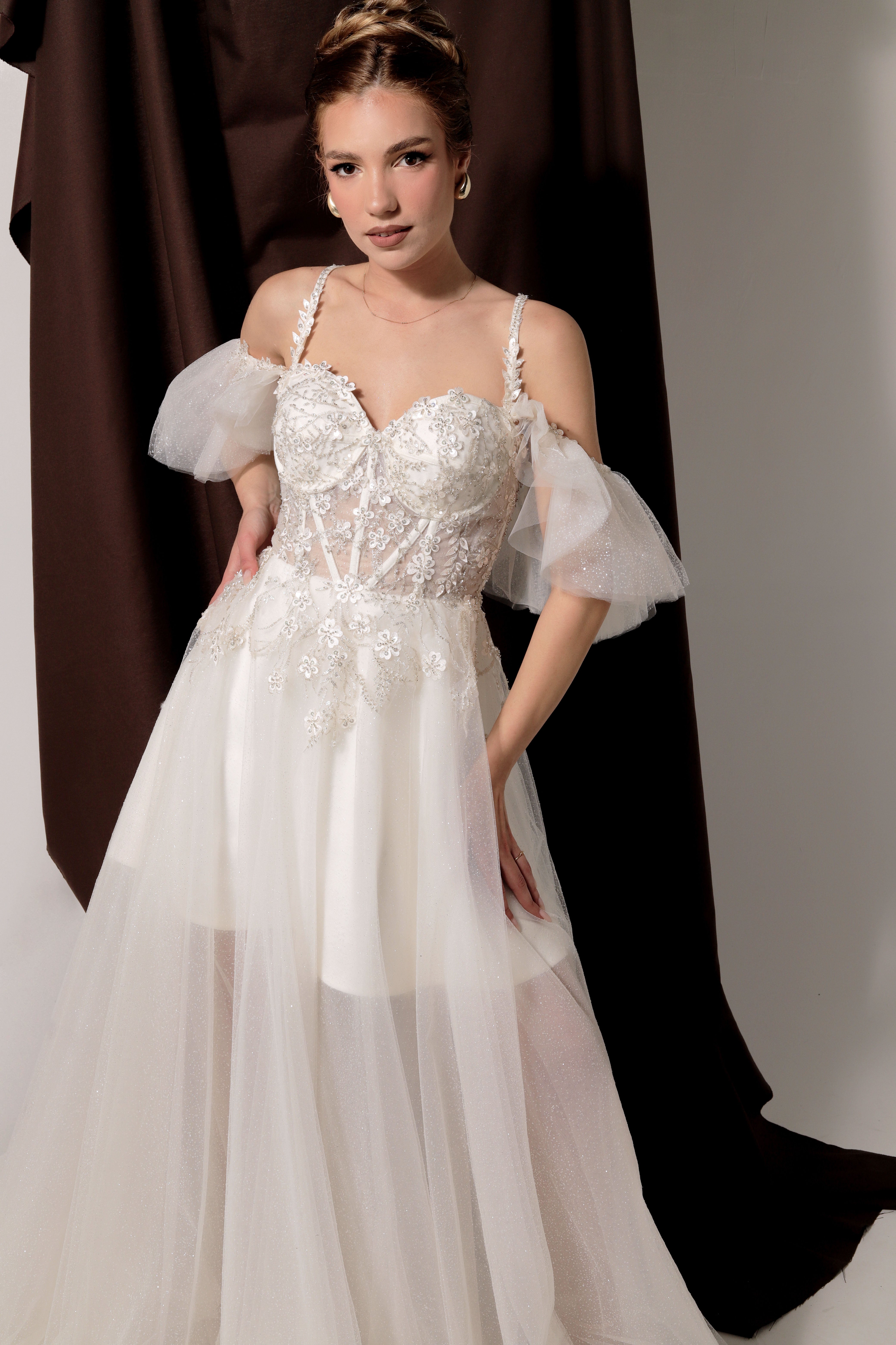 Дълга булчинска рокля Felicity LIZA KAIN София. Бяла официална тюлена рокля. Сърцевидно деколте с чашки и презрамки с блестяща флорална дантела. Дълга прозрачна тюлена пола с подплата. Паднали ръкави.