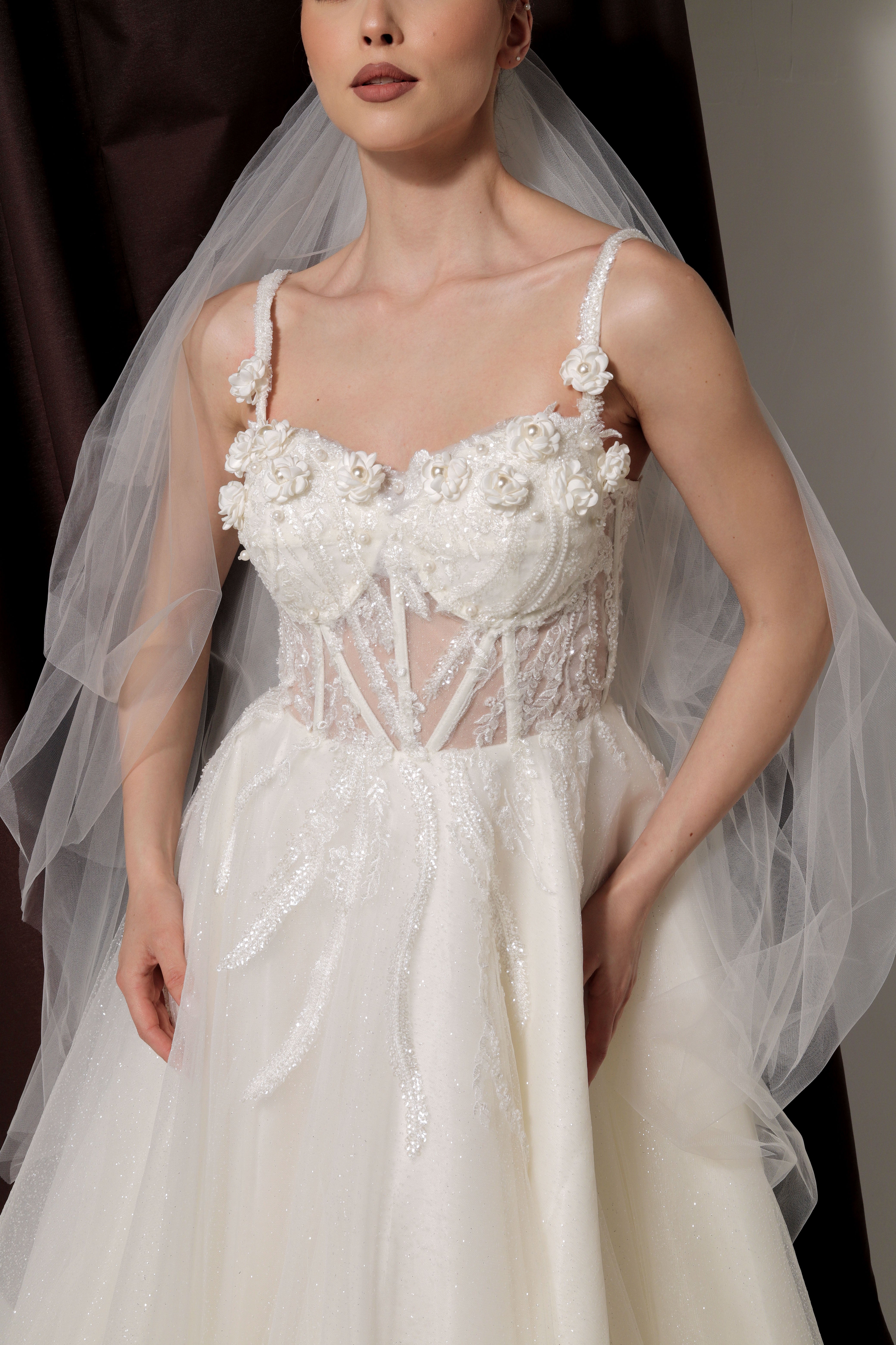 Дълга булчинска рокля Celestia LIZA KAIN София. Официална бяла рокля. Корсет с чашки и презрамки с прозрачна основа и апликации от цветя. Обемна пола от тюл. Воал.