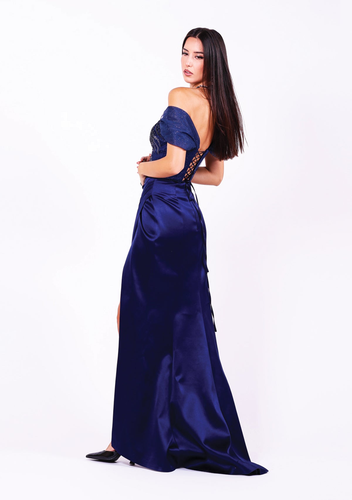 Дълга абитуриентска рокля Kyanite LIZA KAIN София. Официална рокля от тъмносин сатен. Корсет с деколте с мрежа и паднали ръкави. Връзки на гърба. Пола със силует русалка с шлейф.