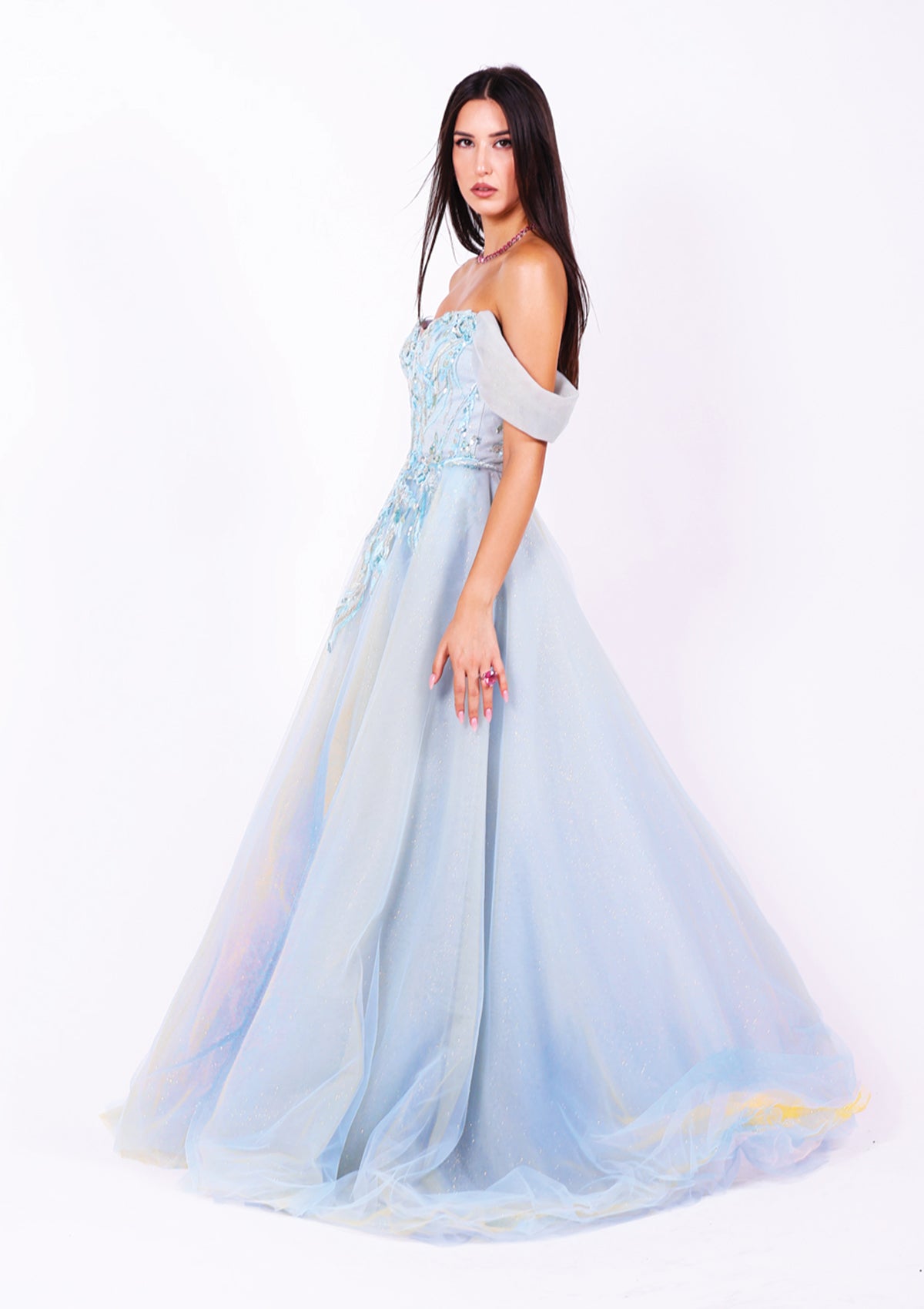 Дълга абитуриентска рокля Larimar LIZA KAIN София. Официална рокля от синьозелен тюл. Корсет с деколте с мрежа и паднали ръкави. Връзки на гърба. Покрита с дантела от мъниста. Обемна пола от различни слоеве тюл.