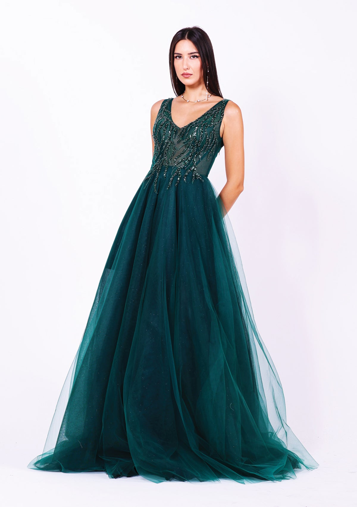 Дълга абитуриентска рокля Maera LIZA KAIN София. Официална рокля от зелен тюл. Корсет с V-образно деколте с презрамки, покрит със зелена пълзяща дантела. Обемна тюлена пола от различни слоеве тюл с къса подплата.