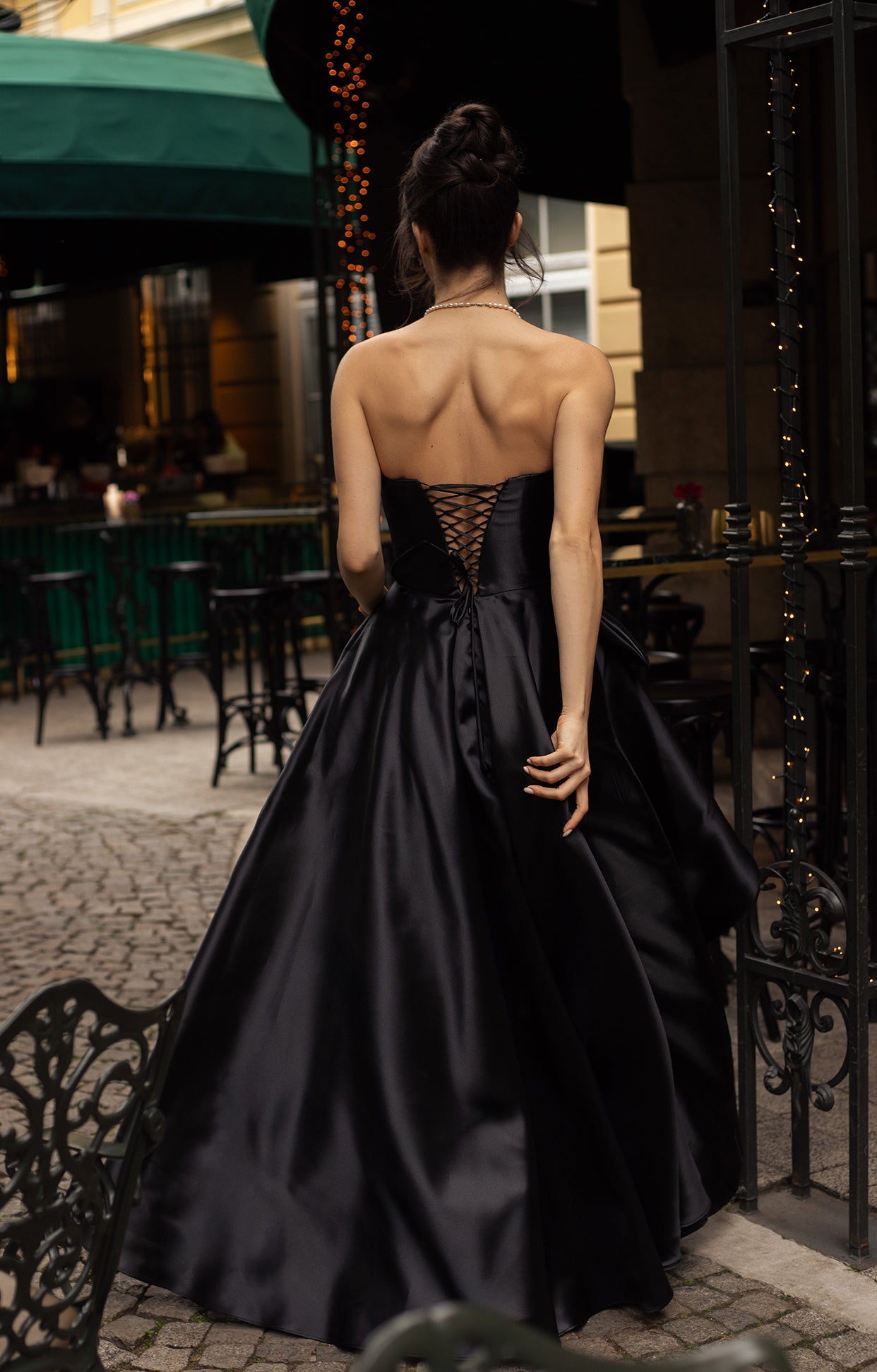 Официална дълга абитуриентска рокля Onyra LIZA KAIN София. Асиметричен обемен силует от черна органза. Връзки на гърба и обемна пола с плохи.