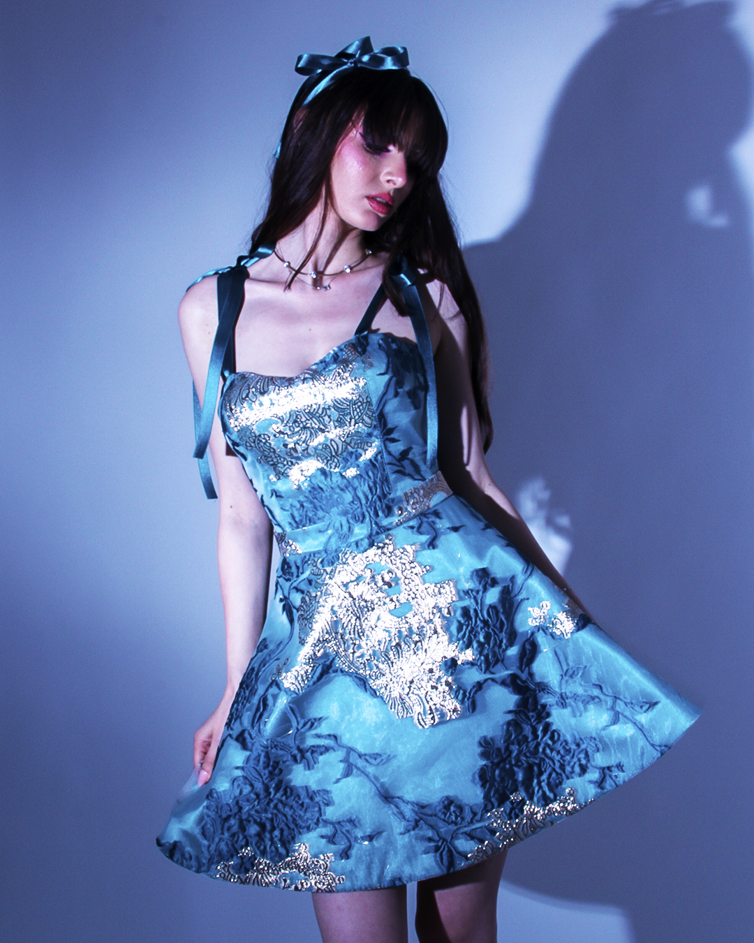 Къса рокля Philomena LIZA KAIN София. Официална рокля от син жакард с флорален десен. Корсет със сърцевидно деколте и презрамки тип панделка. Разкроена пола пълен клош.