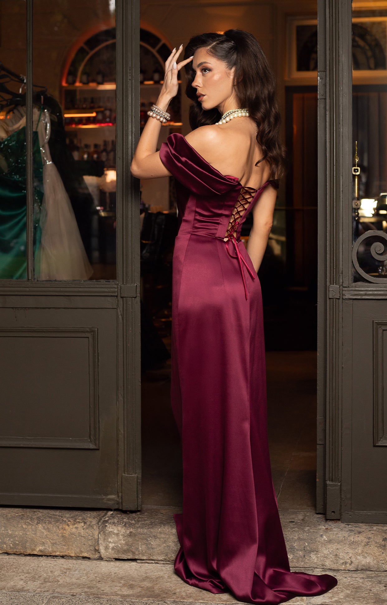 Официална дълга абитуриентска рокля Seqra LIZA KAIN София от сатен в цвят бордо. Срязан корсет с деколте с асиметрични паднали ръкави с драперия. Връзки на гърба.