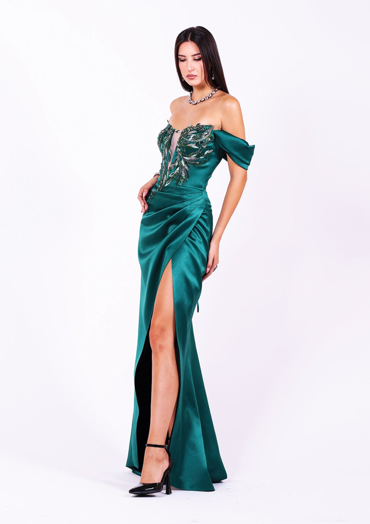 Дълга абитуриентска рокля Seraphinite LIZA KAIN София. Официална зелена сатенена рокля. Корсет с паднали ръкави и V-образна мрежа, покрит с флорална дантела. Пола по тялото с плохи и висока цепка с прехлупване.