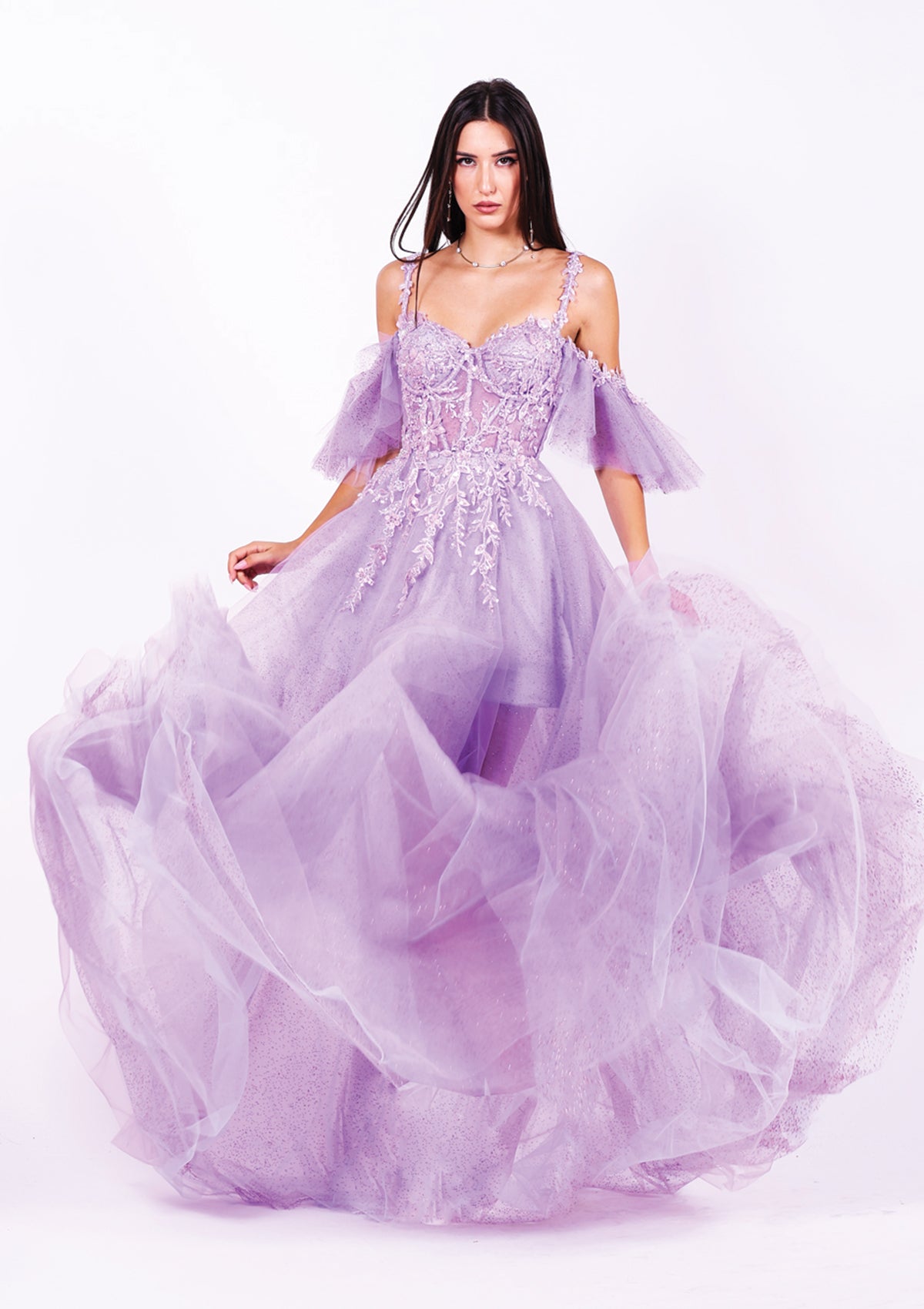 Дълга абитуриентска рокля Tourmaline LIZA KAIN София. Официална рокля от лилав тюл. Корсет с чашки, презрамки и паднали ръкави. Покрита с флорална сребриста дантела. Бухнала тюлена пола с къса сатенена подплата.