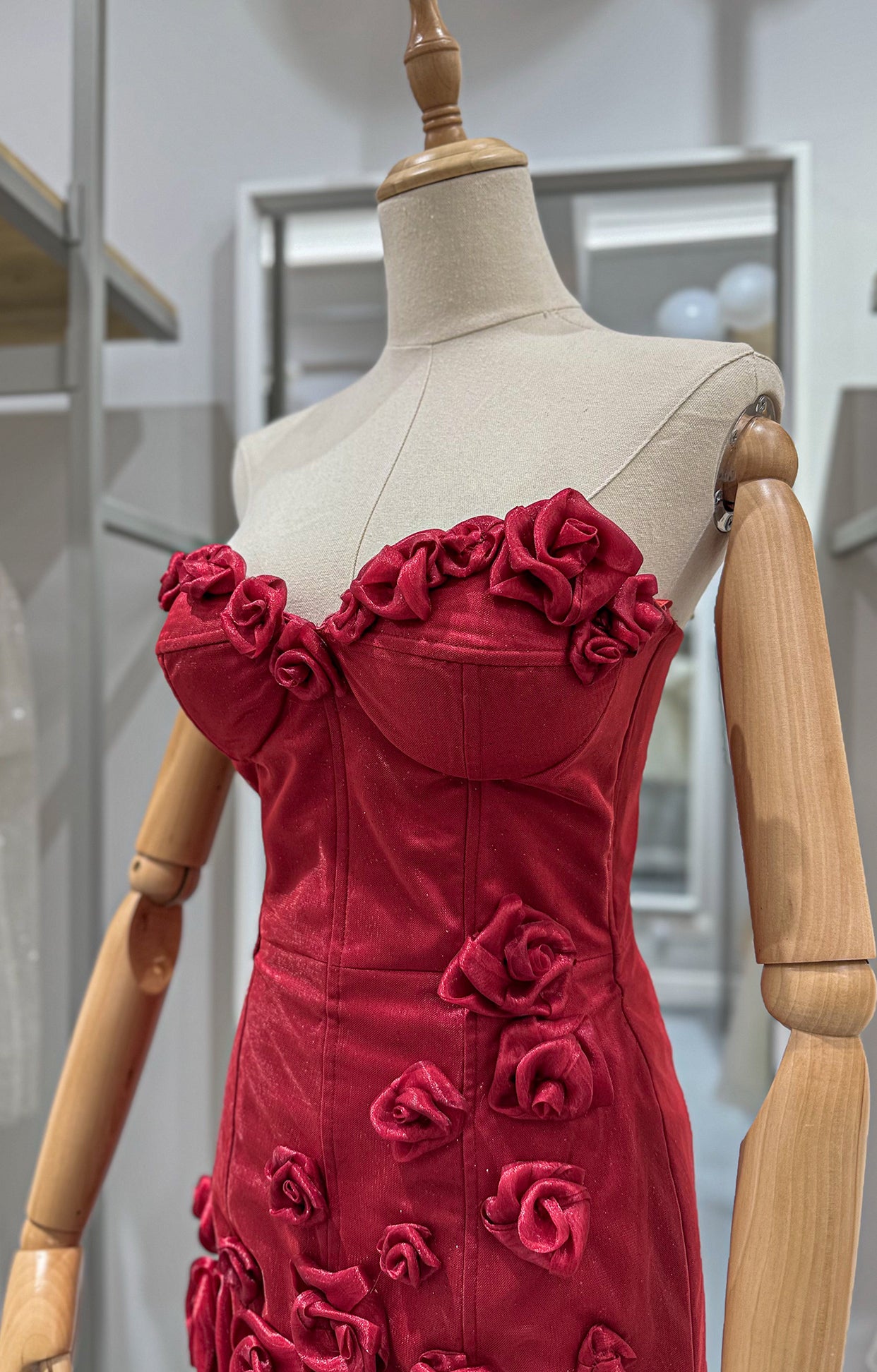 Къса официална рокля Rosette LIZA KAIN София. Мини коктейлна рокля от червена блестяща материя. Корсет с чашки без презрамки и с апликации от цветя по деколтето. Пола с апликации от 3D рози.