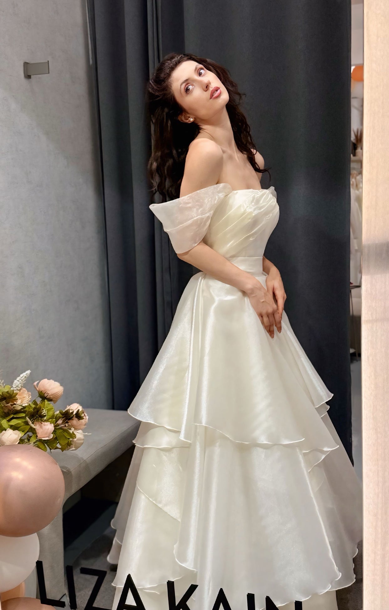 Дълга булчинска рокля Aveline LIZA KAIN София. Бяла официална рокля от органза. Корсет с равно деколте с драперия и паднали ръкави. Обемна пола с колан и волани.