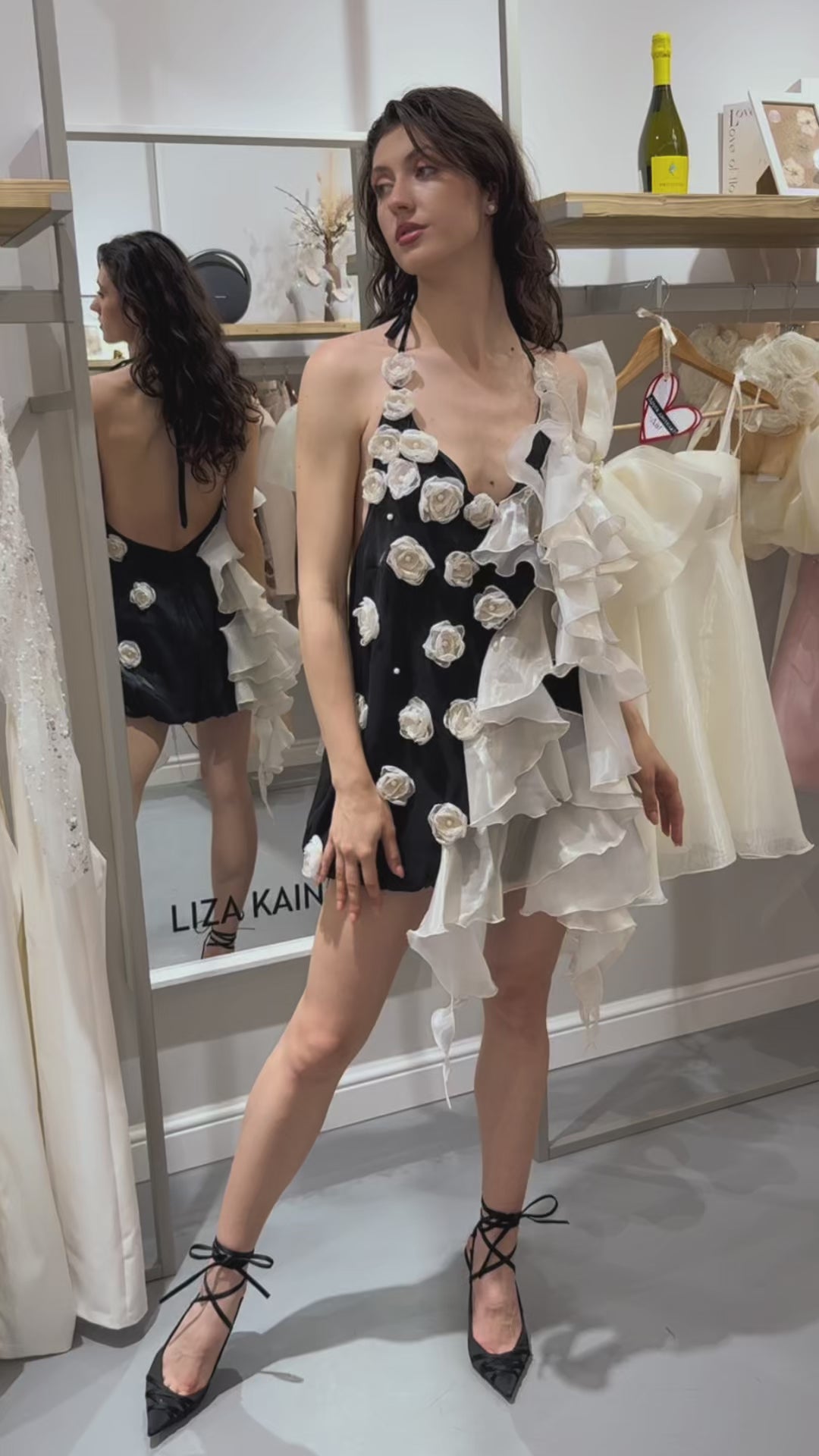 Къса официална рокля Midnight Veil LIZA KAIN София. Мини асиметрична рокля от черна и бяла органза с една част от падащи волани, а друга от цветя от органза. С връзки на врата.