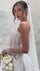 Сватбена рокля Emeralda Bohéme от LIZA KAIN bridal, допълнена от ефирен воал с деликатни орнаменти. Аксесоарът хармонизира перфектно с флоралната дантела и триизмерните елементи на корсета. Композицията създава усещане за съвременна елегантност.