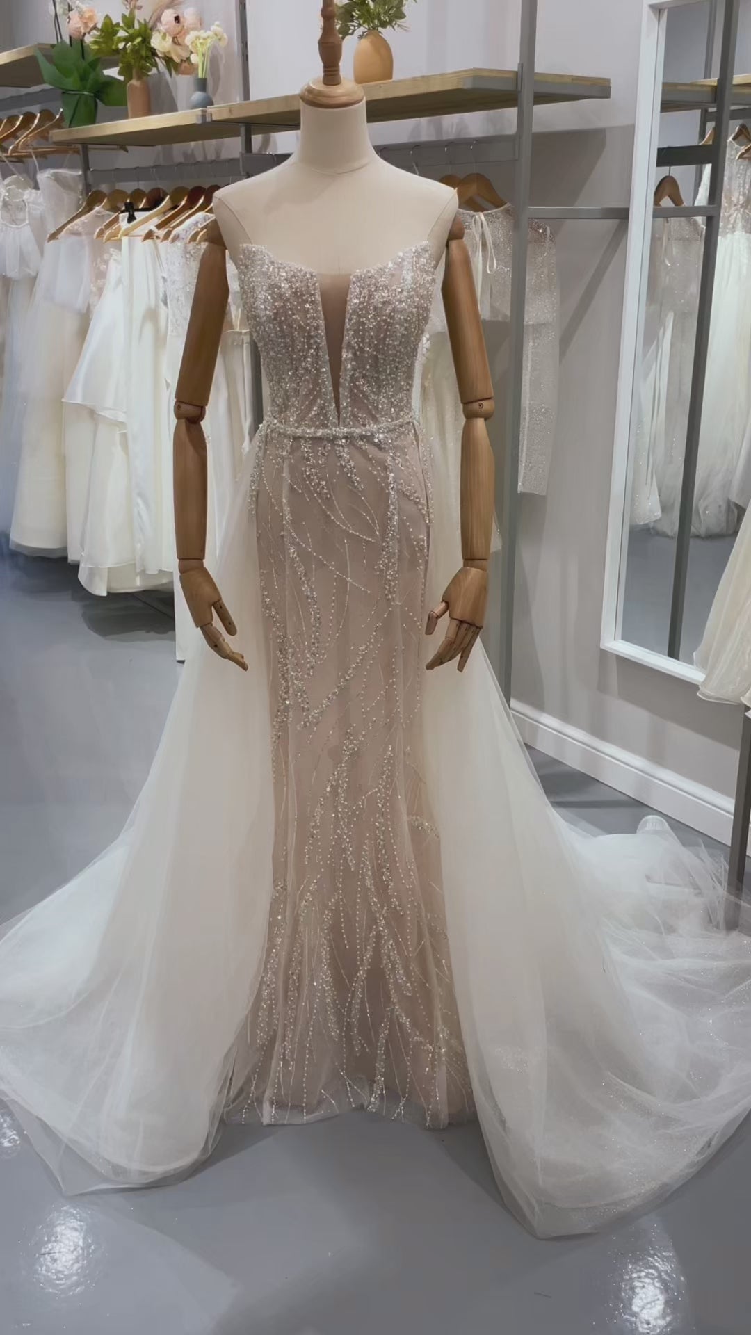 Дълга булчинска рокля русалка Rubelle Grande LIZA KAIN София. Бяла официална рокля с телесна основа, покрита с дантела от мъниста и перли. Изострен корсет с V-образно деколте с мрежа и връзки с панел на гърба. Основна пола по тялото и бухнала тюлена пола с колан от перли.