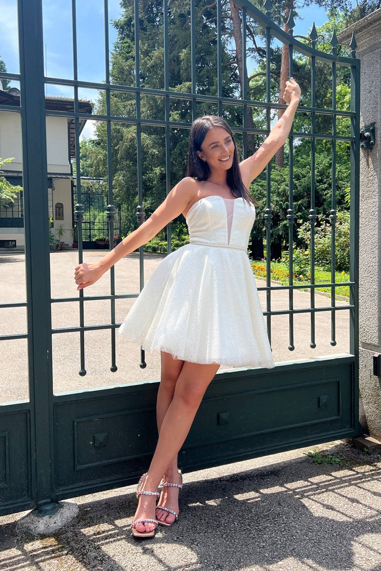 Къса булчинска рокля Elegant Mini LIZA KAIN София. Официална бяла мини рокля от тюл с брокат. Корсет със сърцевидно деколте с мрежа. Разкроена пола.
