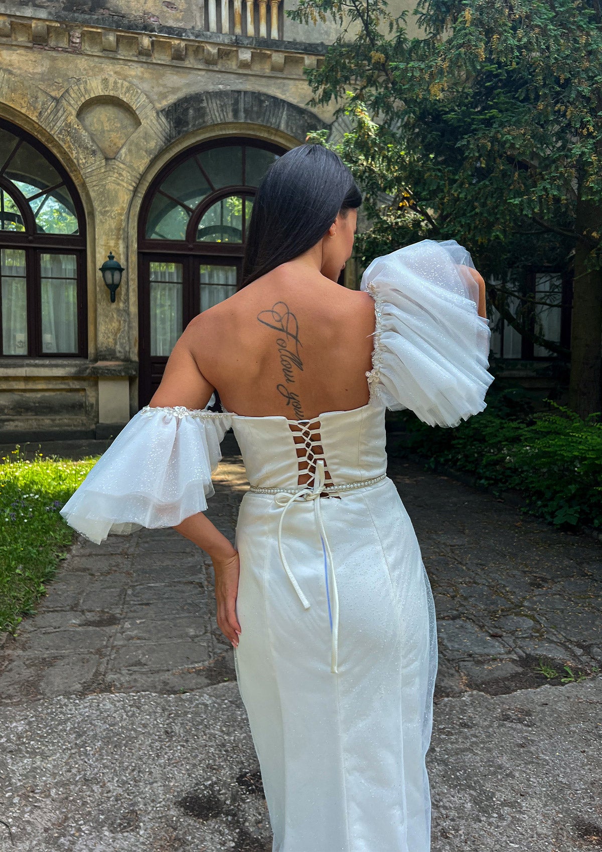 Дълга булчинска рокля Hourglass Haven LIZA KAIN София. Официална сатенена рокля с обемни тюлени презрамки, покрита от слой блестяш тюл. Корсет, покрит със сребриста дантела. Тънък колан от камъчета. Права пола с плохи и цепка. Дантела по полата.